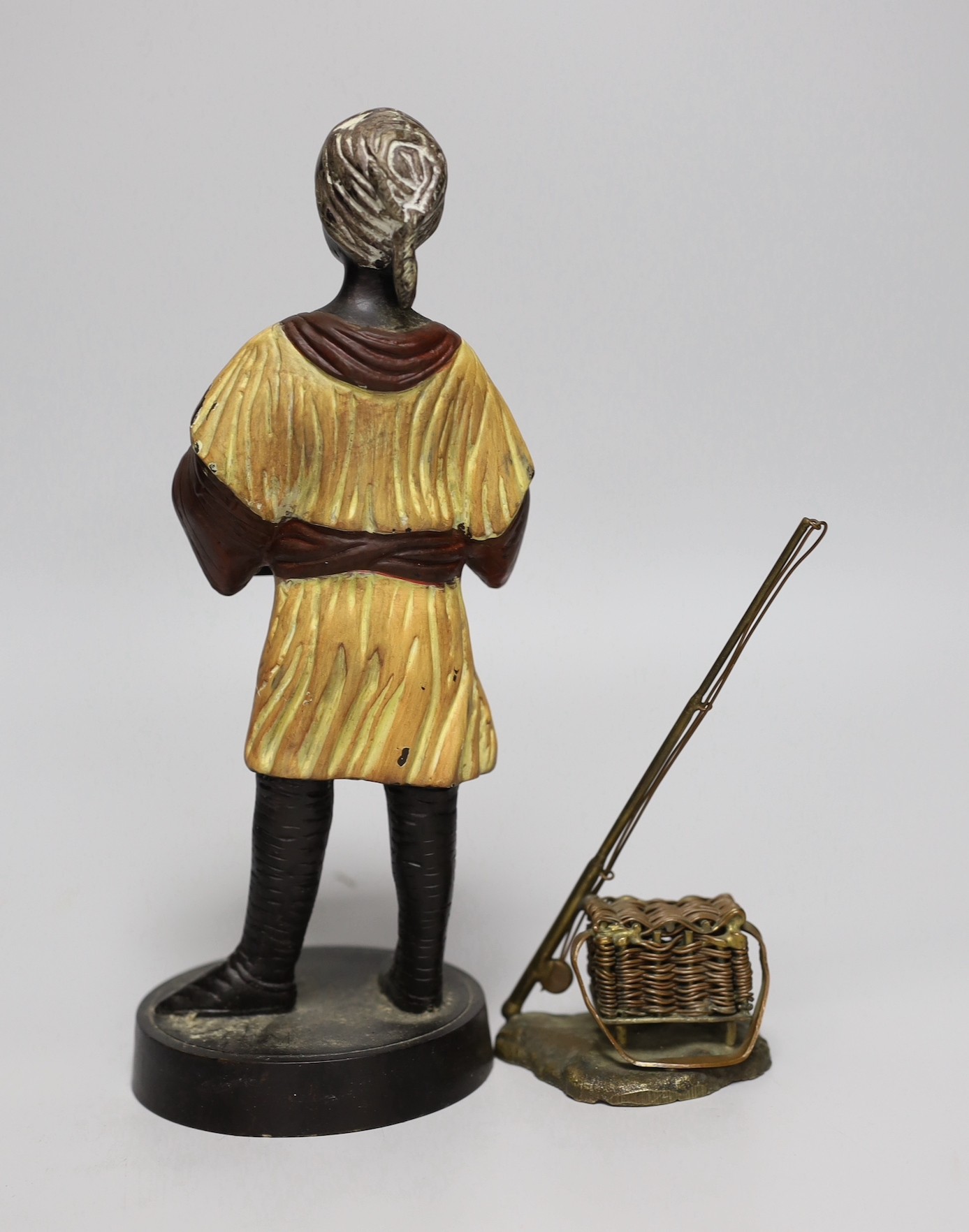 A bronzed spelter figure and cast brass fishing rod and basket, figure 27cms high